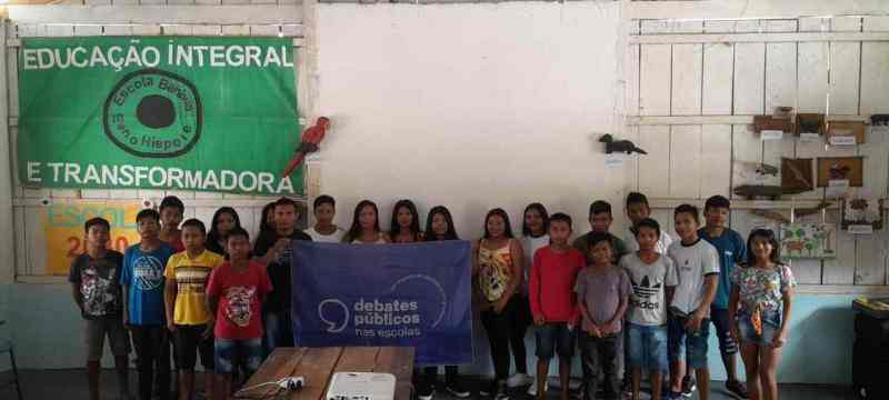 Um grupo de jovens reunidos segurando a bandeira dos Debates Públicos das Escolas
