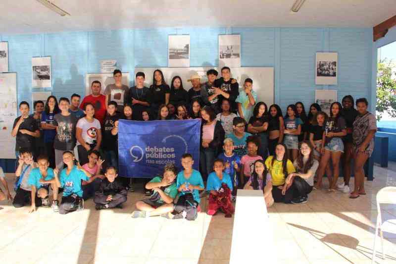 Vários jovens com a bandeira dos Debates Públicos nas Escolas