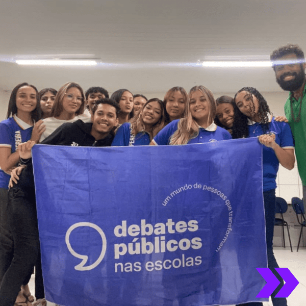 Um grupo de jovens reunidos segurando a bandeira dos Debates Públicos das Escolas