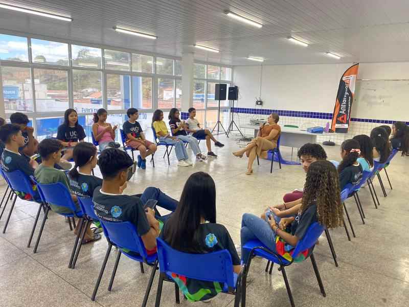 Um grupo de jovens reunidos em semicirculo