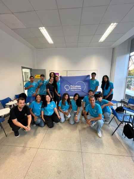  Imagem de um grupo de jovens reunidos no Centro de Referência da Juventude, em Belo Horizonte (MG), segurando a bandeira do projeto Debates Públicos nas Escolas